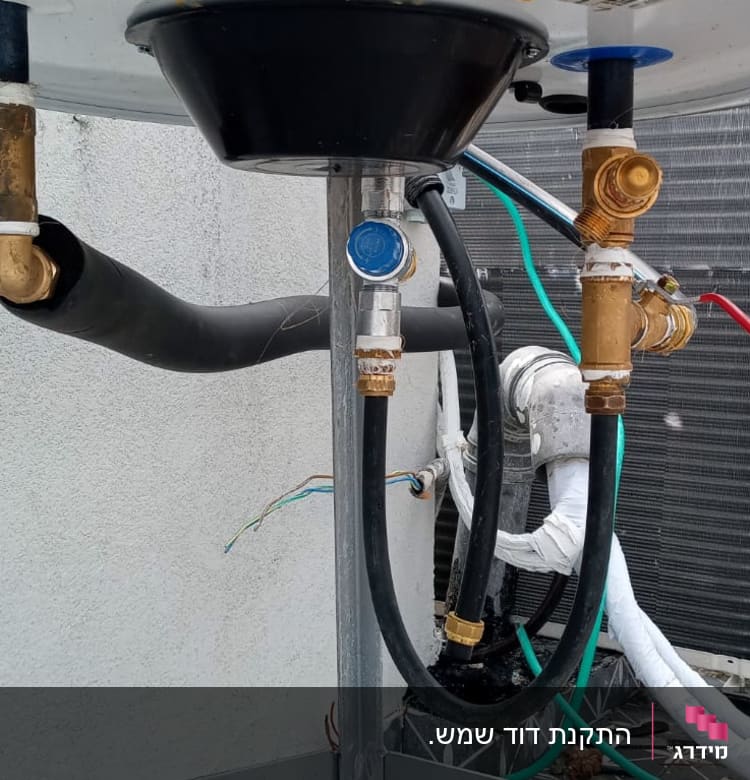 חיבורים וצינורות מתחת לדוד שמש על גג